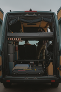 Van interior with adjustable bed system and text highlighting adjustability built-in.