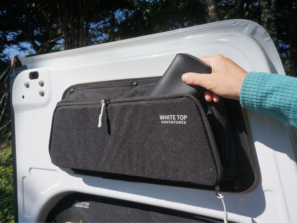 person placing item in rear van door storage pouch